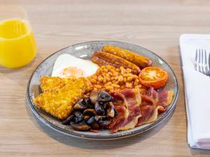 a plate of breakfast food with eggs bacon beans and toast at Novotel Liverpool Paddington Village in Liverpool