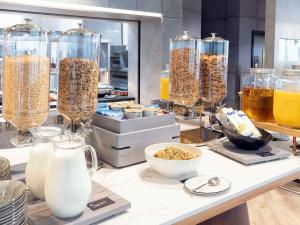 a counter with many glass containers of cereals and milk at Novotel Liverpool Paddington Village in Liverpool