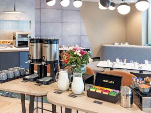 a table with a coffee maker and flowers on it at Novotel Liverpool Paddington Village in Liverpool