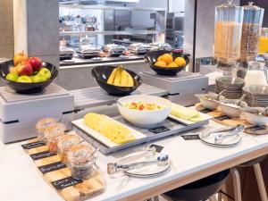 a buffet with bowls of fruits and vegetables on a counter at Novotel Liverpool Paddington Village in Liverpool