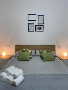 een bed met groene kussens en handdoeken erop bij Maison Silvia in Napels