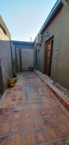 un patio de ladrillo con puerta y edificio en La casita de la San Martín en San Fernando del Valle de Catamarca