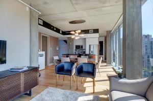 sala de estar de planta abierta con mesa y sillas en Les Immeubles Charlevoix - Le 760805, en Quebec