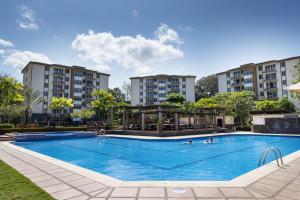 a pool at a hotel with buildings in the background at 3Room Jaco Condos in Jacó
