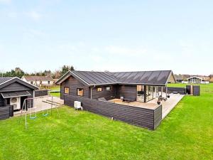 a house with a large yard with green grass at Modern Cottage with Spa - By Traum Ferienwohnungen in Vinderup