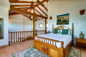 um quarto com uma cama de madeira num quarto em Villa 99-Beachfront-Pool-Luxury Villa em Placencia Village