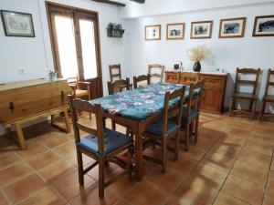 uma sala de jantar com mesa e cadeiras e um piano em Casa Roya em Montalbán