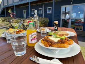 uma mesa com dois pratos de comida e uma garrafa de sumo em LKNZ Lodge & Cafe em Ohakune