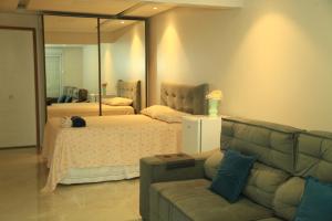 uma sala de estar com um sofá e um espelho em Valentina 24 HORAS em Florianópolis