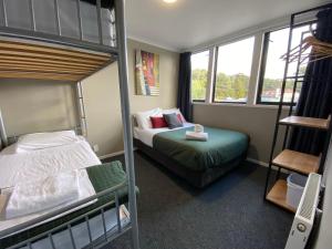 a bedroom with two bunk beds and a ladder at LKNZ Lodge & Cafe in Ohakune