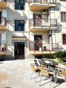 une terrasse avec une table et des chaises devant un bâtiment dans l'établissement LOFT ORTENSIA, à Pompéi