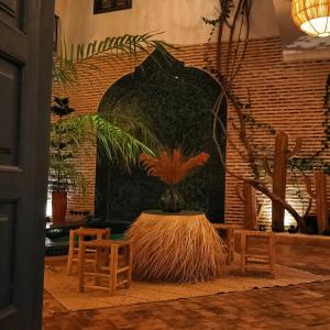 a room with a table and two chairs and a plant at Riad Dar Marrakcha in Marrakesh