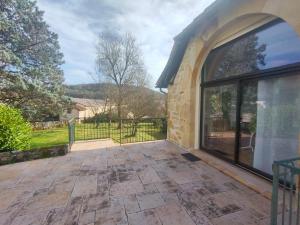 a patio with a large window on a building at La Grange de Lili in Figeac