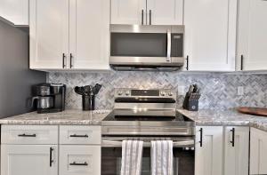 cocina con fogones de acero inoxidable y microondas en Rutland's Hidden Gem- 2 BR 1BA Renovated Home Close to Everything home en Rutland