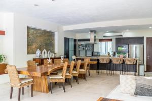a kitchen and dining room with a wooden table and chairs at Vallarta Gardens V4 -Alberca y Roof Garden Private in Cruz de Huanacaxtle