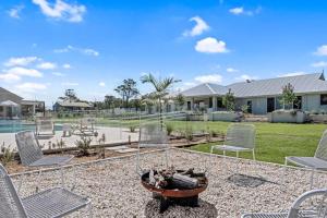 eine Gruppe von Stühlen und eine Feuerstelle in einem Hof in der Unterkunft Luxury Hunter Valley Estate in Lochinvar