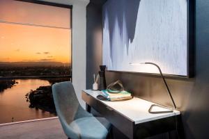 a desk with a lamp and a chair next to a window at Circle on Cavill - Self Contained Apartments - Wow Stay in Gold Coast