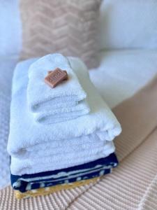 uma pilha de toalhas com um sabonete por cima em Salty Paws Dog Friendly Luxe Cottage em San Remo