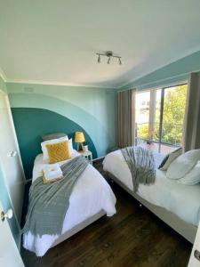 a bedroom with two beds and a window at Salty Paws Dog Friendly Luxe Cottage in San Remo