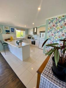 a kitchen with a plant in the middle of it at Salty Paws Dog Friendly Luxe Cottage in San Remo