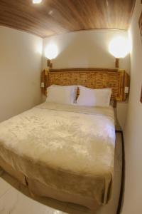 a bedroom with a large bed with a wooden headboard at Casa do Imperador in Fernando de Noronha