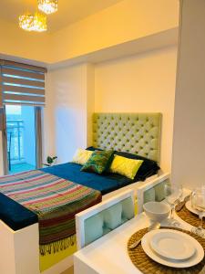 a bedroom with a bed and a table with a dining room at VVJ Staycation at Azure North, Bali 1526 in San Fernando