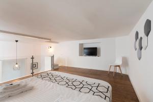 Habitación blanca con cama y TV en ramo d'oro en Nápoles