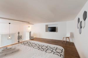 Cette chambre blanche dispose d'un lit et d'une télévision. dans l'établissement ramo d'oro, à Naples