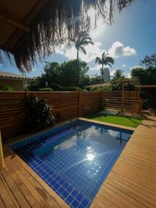 una piscina en un patio con terraza de madera en Casa do Imperador, en Fernando de Noronha