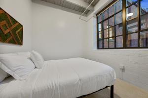 Ein Bett oder Betten in einem Zimmer der Unterkunft Industrial Loft Apartments in the Beautiful Superior Building Minutes from FirstEnergy Stadium 220