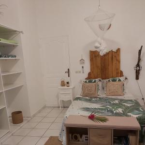 a bedroom with a bed with a wooden headboard at Le Biabiany in Bouillante