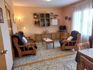a living room with two chairs and a table at Cal Serveró in Peramola