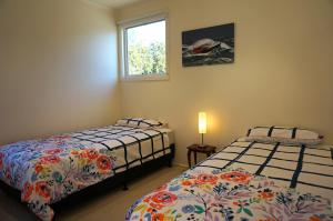 um quarto com 2 camas e uma janela em Rip Tide em Point Lonsdale