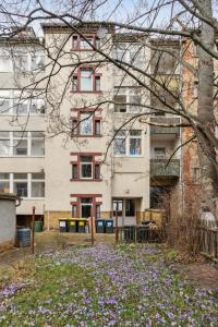 apartamentowiec z fioletowymi kwiatami przed nim w obiekcie Apartment für 10 Gäste, 2 Bäder, 2 Loggia's, Leipzig Zentrum Ost w Lipsku