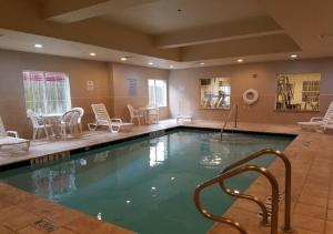 a swimming pool with chairs and chairs in a room at La Quinta by Wyndham Houston - Magnolia in The Woodlands