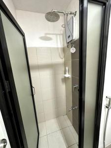a shower with a glass door in a bathroom at Sevilla's Place in Tagaytay