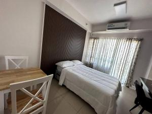 a bedroom with two beds and a table and a window at Sevilla's Place in Tagaytay