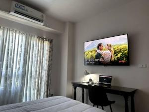 een slaapkamer met een tv aan de muur bij Sevilla's Place in Tagaytay