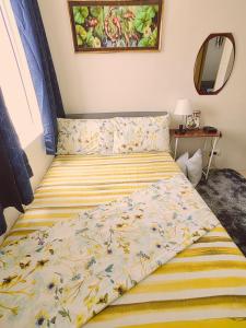 1 dormitorio con 1 cama con edredón amarillo y azul en 8 spatial condo near downtown, coffee shop, SNR, Sm, hospital, Schools 2b fully furnished, en Davao City