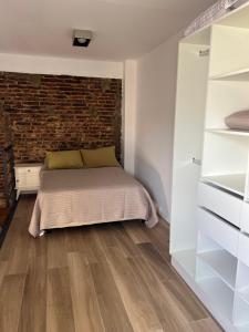 a bedroom with a bed and a brick wall at Loft .Once de Abril in Bahía Blanca