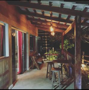un porche de una casa con mesa y sillas en Pousada Toca da Raposa en Cavalcante