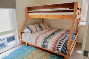 a bunk bed with a wooden bunk bed frame in a room at Beachcomber in Point Lonsdale
