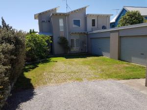 a house with a yard with a garage at Beachcomber in Point Lonsdale