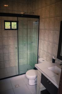 a bathroom with a toilet and a glass shower at Casa de Campo La Montaña in Tarija
