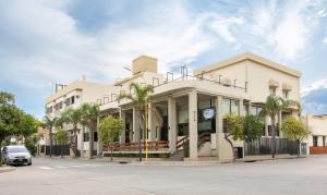biały budynek z palmami przed nim w obiekcie Catalina Hotel San Pedro de Jujuy w mieście San Pedro de Jujuy