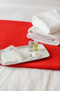 eine Zahnbürste und eine Tube Zahnpasta und Handtücher in der Unterkunft Crystal Hotel in Levallois-Perret