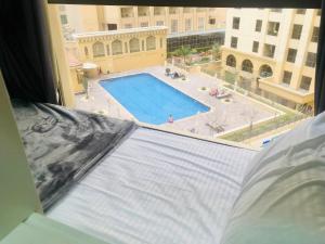 a view of a swimming pool from a window at The beach hostel Dubai in Dubai