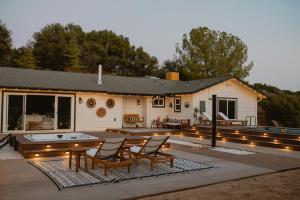 a patio with a table and chairs and a house at Boho chic oasis by Casa Oso with pool, spa and views in Ahwahnee