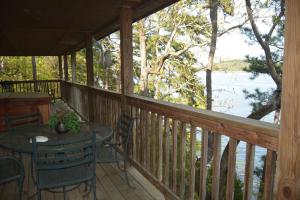 porche con mesa, sillas y vistas al agua en C14, Two bedroom, two bath, log-sided, luxury Harbor North cottage overlooking the lake, cottage, en Mount Ida