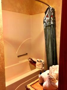a bathroom with a tub and a shower curtain at C13 - Forest View two bedroom, two bath Harbor North luxury loft cottage with private hot tub o Lake on Ouachita in Mount Ida